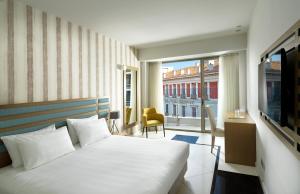 a hotel room with a bed and a balcony at Athens Tiare by Mage Hotels in Athens