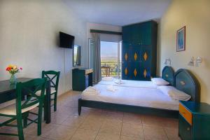 a bedroom with a bed and a table and a desk at Pinelopi Apartments in Georgioupolis +28 photos