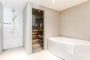 a bathroom with a tub, toilet and shower stall at Best Western Plus Savoy Lulea in Luleå