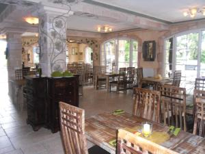 a restaurant with wooden tables and chairs and windows at Seehotel Europa in Schwanau