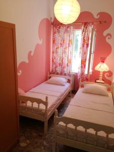 two beds in a room with pink walls at Villa Nostra - Kruče in Ulcinj