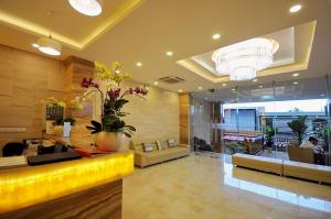 a lobby with a yellow couch and a large room at Boss Hotel in Nha Trang