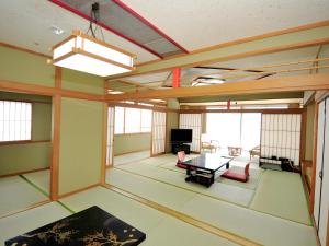 a large living room with a table and a tv at Nisshokan Shinkan Baishokaku in Nagasaki
