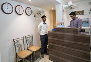 BnB Hotel في لاهور: رجلان يقفان عند كونتر في متجر