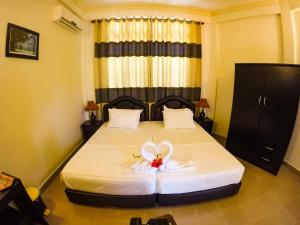 ein Schlafzimmer mit einem Bett mit einer Blume darauf in der Unterkunft Hanifaru Transit Inn in Dharavandhoo