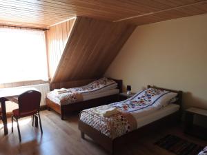 1 dormitorio con 2 camas, mesa y ventana en Gospodarstwo Kaczynski Ostrołęka, en Wyszel