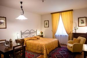 a bedroom with a bed and a table and a chair at Palazzo La Fenice in Massa Marittima