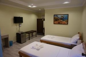 Habitación de hotel con 2 camas y TV en Wellbeach Dive Resort en Zamboanguita