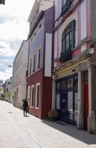 a person walking down a street next to buildings at Wok Rooms in Brussels