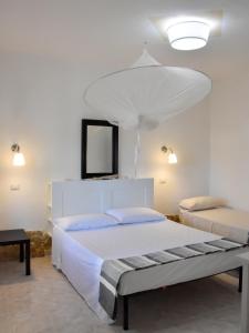 トッレ・ファロにあるCasa Bianca Ammareの白いベッドルーム(大型ベッド1台、鏡付)
