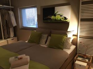 a bedroom with a bed with green and white pillows at WohnRaum Hotel & Gästehaus in Gusterath