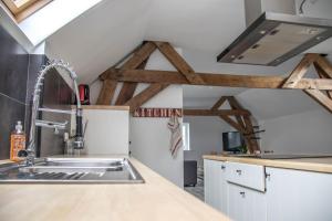 a kitchen with a sink and wooden beams at Jules place in Wakken