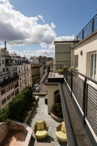 a balcony with chairs and a view of a city at Majestic Hotel Spa - Champs Elysées in Paris