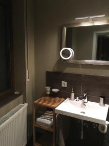 ein Bad mit einem Waschbecken und einem Spiegel in der Unterkunft WohnRaum Hotel & Gästehaus in Gusterath
