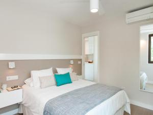 サンアグスティンにあるBeachfront Apartment Siesta 21 San Agustin Playa by VillaGranCanariaのベッドルーム(青い枕の大きな白いベッド付)