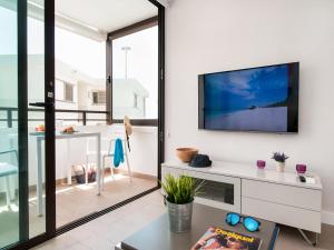 A television and/or entertainment centre at Beachfront Apartment Siesta 21 San Agustin Playa by VillaGranCanaria