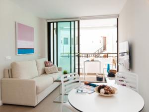 サンアグスティンにあるBeachfront Apartment Siesta 21 San Agustin Playa by VillaGranCanariaのリビングルーム(白いソファ、テーブル付)