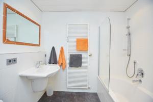 a white bathroom with a sink and a shower at Alpenflair Ferienwohnungen Whg 101+213 in Oberstdorf +26 photos