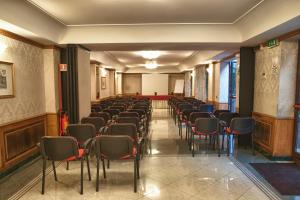 una stanza con una fila di sedie e tavoli di Hotel Cilicia a Roma