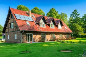 ein großes Backsteinhaus mit einem roten Dach in der Unterkunft Komfortferienwohnungen Spreewalder Auszeit in Burg