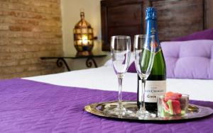 Una botella de vino y dos copas en una mesa. en Casa de Federico Boutique, en Granada