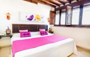 1 dormitorio con 1 cama grande con almohadas moradas en Casa de Federico Boutique, en Granada