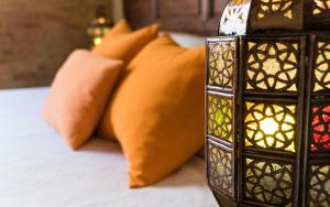 a bed with orange pillows and a candle at Casa de Federico Boutique in Granada