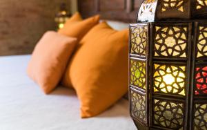 Una cama con almohadas naranjas y una vela en Casa de Federico Boutique en Granada