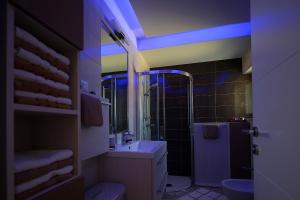 a bathroom with a sink and a shower with blue lights at Apartment Porpo in Malinska +12 photos