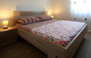 a large bed in a bedroom with two lamps at Apartment Porpo in Malinska