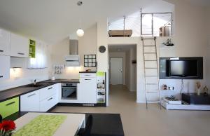 a kitchen with white cabinets and a tv in it at Apartment Porpo in Malinska