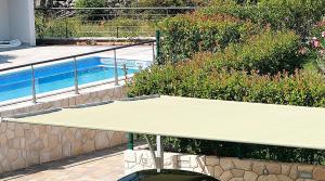 a tennis racket sitting next to a swimming pool at Apartment Porpo in Malinska