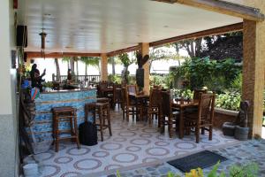 a restaurant with tables and chairs and a bar at Wellbeach Dive Resort in Zamboanguita