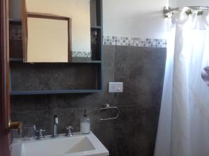 W łazience znajduje się umywalka i lustro. w obiekcie Posada Buen Camino w mieście Nono