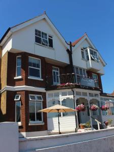 a building with an umbrella in front of it at Beamsley Lodge B&B in Eastbourne