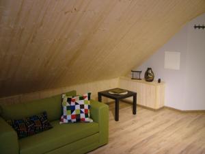 a living room with a green couch and a table at Mill Hause Apart 1 in Druskininkai