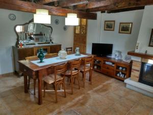 a dining room with a table and chairs and a television at Casa Cal Galceran in Alás