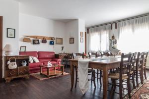 sala de estar con mesa y sofá rojo en Casa Bibi en Cartiera Reali