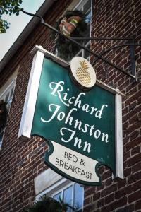 una señal para un restaurante en un edificio de ladrillo en The Richard Johnston Inn & 1890 Caroline House, en Fredericksburg