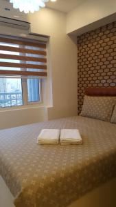 - une chambre avec un lit et 2 serviettes dans l'établissement Breeze Residences by CS Luxe, à Manille