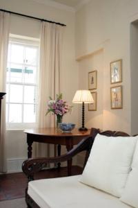 Cette chambre comprend une table avec une lampe et des fleurs. dans l'établissement De Kothuize 18, à Graaff-Reinet