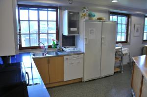 a kitchen with a white refrigerator and a sink at Vimmerby Vandrarhem in Vimmerby