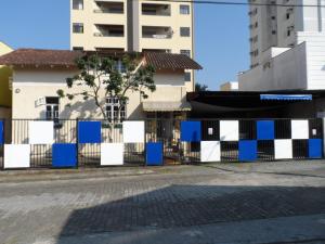 a fence with blue and white squares in front of a building at Austria Hostel & Pousada in Blumenau +28 photos
