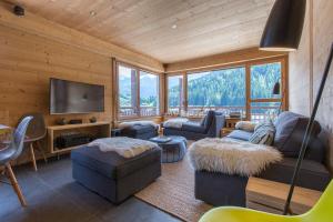 a living room with couches and a flat screen tv at Appartement Le Danay 10 personnes in Le Grand-Bornand