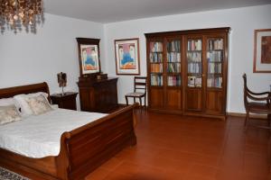 a bedroom with a bed and wooden furniture and chairs at Caloura Camellia House in Caloura