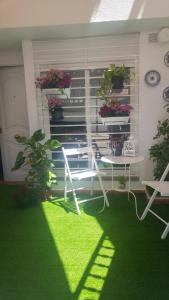 マイレナ・デル・アルハラフェにあるCasa Daleの緑の芝生と白いテーブルと椅子が備わる部屋