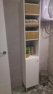 baño con armario blanco con toallas y lavamanos en Casa Dale, en Mairena del Aljarafe