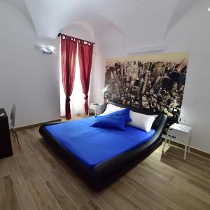 una camera con letto blu e tende rosse di Suite Varigotti a Varigotti
