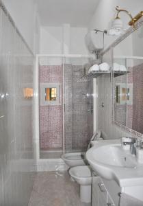 ローマにあるPetrarca n.8の白いバスルーム(洗面台2台、トイレ付)