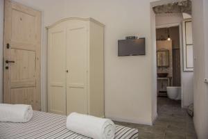 a bedroom with a bed and a tv on a wall at Apartment Sotto Il Santo in Orco Feglino
